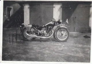 Motocykl před hospodářskou budovou